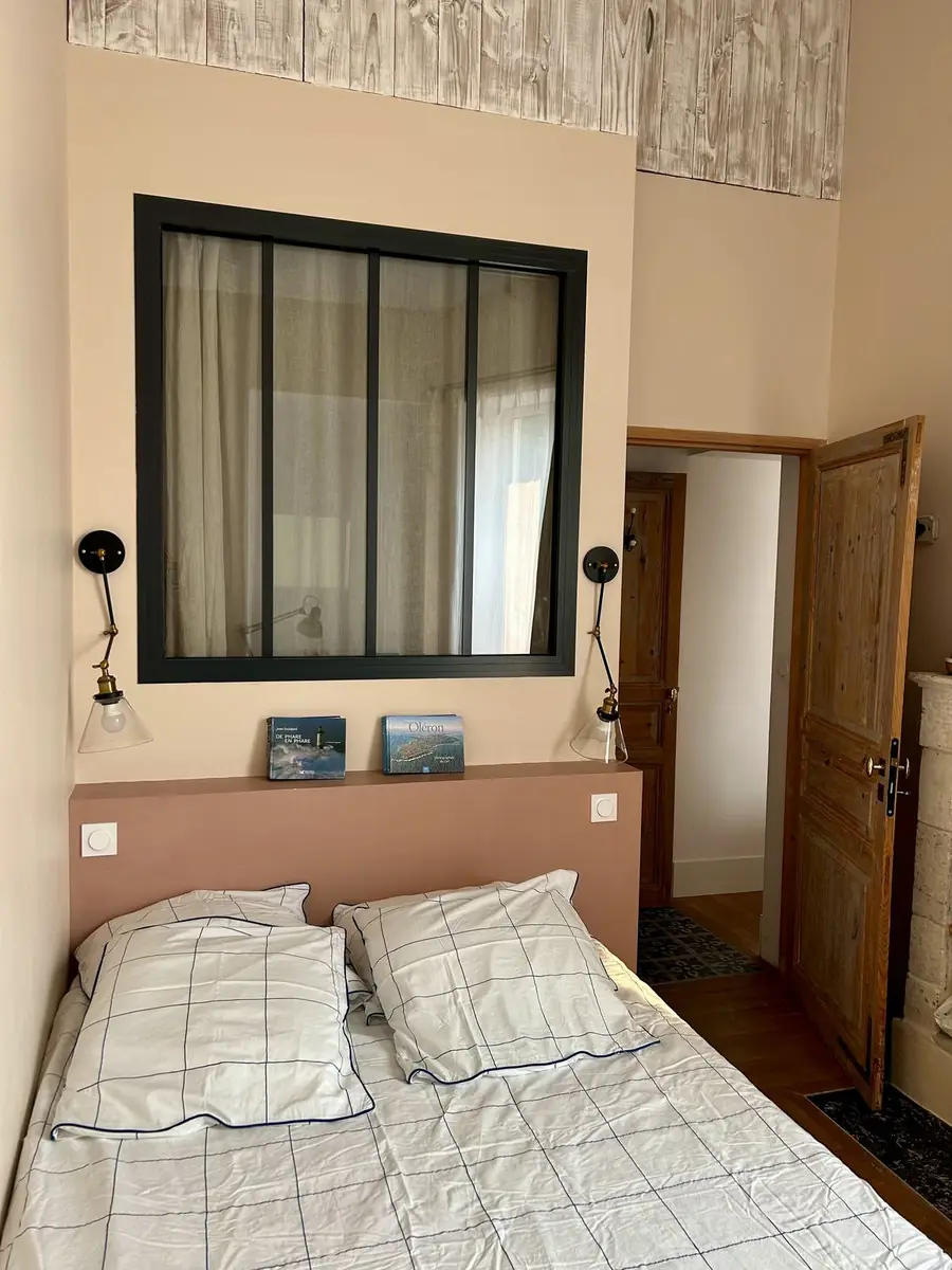 Chambre avec tête de lit terracotta et verrière